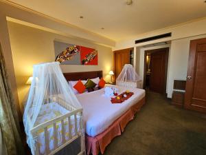 素攀武里松法布里酒店的酒店客房带一张床和一张婴儿床