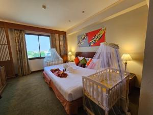 素攀武里松法布里酒店的酒店客房设有一张床和一个大窗户