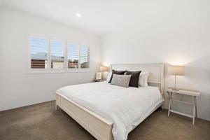 珀斯Modern Minimalistic Home 3BR的白色的卧室设有一张大床和一个窗户
