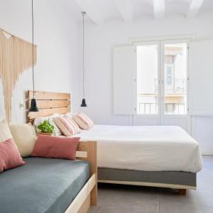巴塞罗那格劳生态精品酒店的一间卧室配有两张床和一张长凳