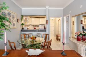 卡帕里卡海岸JOIVY Vibrant flat with balcony的用餐室以及带玻璃桌和椅子的厨房