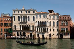 威尼斯The Venice Venice Hotel的建筑物附近水中的一名男子