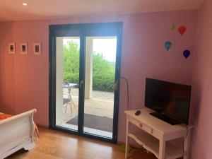 Mûres-les BalmettesMur-Mûres的卧室设有滑动玻璃门,可通往庭院