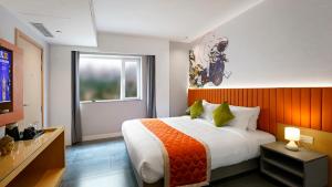 班加罗尔Hotel City Keys By Rivido, Electronic City的一间卧室配有一张带橙色床头板的大床