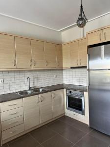 Áyios SpirídhonEVa's Luxury Apartments No 2的厨房配有木制橱柜和不锈钢冰箱。