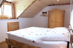 贝希特斯加登Landhaus Kranzbichl的配有木制天花板的客房内的白色床