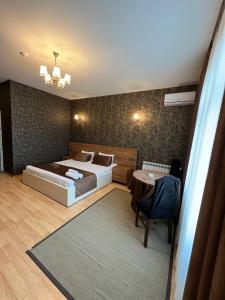 巴库Mardin Hotel Novxanı的卧室配有1张床、1张桌子和1把椅子