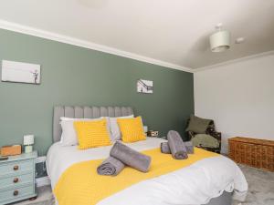 彭里斯Mill End的一间卧室配有一张大床,提供黄色和灰色的枕头