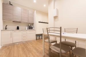 米兰Missori Apartment 1的厨房配有白色橱柜和桌椅