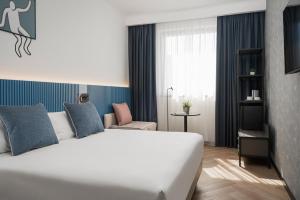 博洛尼亚Mitico Hotel & Natural Spa的卧室配有一张白色大床和一把椅子