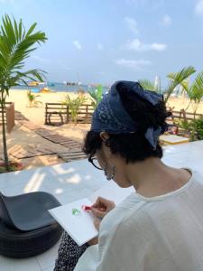 富国SOHO 1 PHÚ QUỐC的一位在海滩上写文章的女性