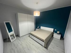 切萨雷奥港Amare Home的一间卧室设有一张床和蓝色的墙壁