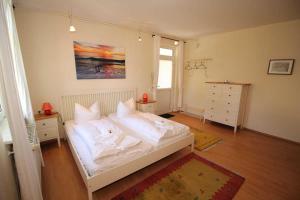 萨斯尼茨Fürstenhof - Apartment 405/406的一间卧室配有带白色床单和枕头的床。