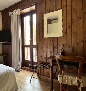 克拉维埃Hotel Ristorante Il Principe的一间卧室配有带镜子的木墙和书桌
