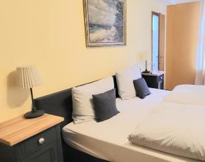 达嫩贝格Hotel Alte Post的一间卧室配有两张床、枕头和灯