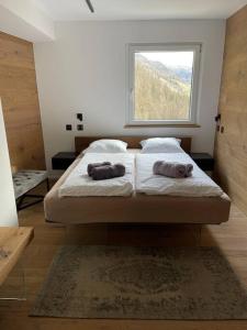 圣莫里茨Luxury Mountain Apartment with Private Sauna and Underground Parking的一间卧室配有带两个枕头的床和窗户
