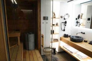 圣莫里茨Luxury Mountain Apartment with Private Sauna and Underground Parking的一间带水槽和玻璃淋浴的浴室