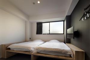 京都三条Piece旅舍的一间卧室设有一张床和一个窗口