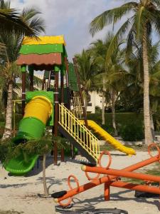 塞拉莱Laguna Apartment HAWANA SALALAH Resort的棕榈树海滩上的游乐场