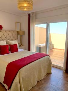 滨海罗克塔斯ÁTICO DELUXE entre CENTRO y PLAYA Salinas con TERRAZA, WIFI, PISCINA climatizada, GYM, SAUNA y GARAJE -Smart TV的一间卧室设有一张大床和一个滑动玻璃门