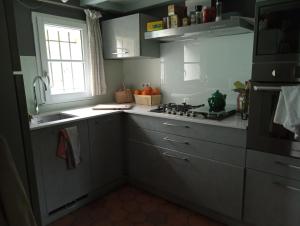 洛特河畔卡斯泰尔莫龙Lulu的厨房配有白色橱柜、水槽和窗户。