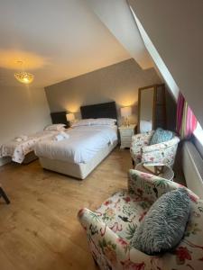 布拉尼Beechwood House Accommodation的一间卧室配有两张床、一张沙发和椅子