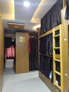 孟买Super Champions Hostel的更衣室,配有黑色衬衫和衣架