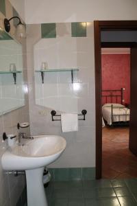 蒙塞利切Agriturismo San Bartolomeo的一间带水槽的浴室和一张位于客房内的床