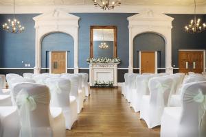达灵顿达灵顿国王美居酒店的白色弓形房的一排椅子