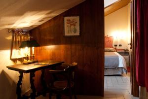克拉维埃Hotel Ristorante Il Principe的一间卧室配有书桌、一张床和一张桌子