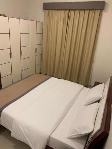 阿吉曼AL MARJAN FURNISHED APARTMENTS的窗户客房内的一张大床