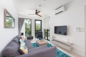 普吉镇Cassia Residence Laguna Phuket Holiday Rental Apartment, Bang Tao Beach的带沙发和电视的客厅