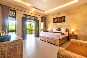 TirtaganggaAlamGangga Villas Tirta Gangga的一间带大床的卧室和一个阳台