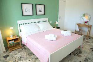 拉古萨码头Villa Ravanica的卧室配有粉红色的床和2条毛巾
