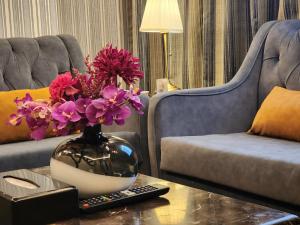 吉达Shaty Alhayat Hotel Suites的客厅,带花瓶的桌子