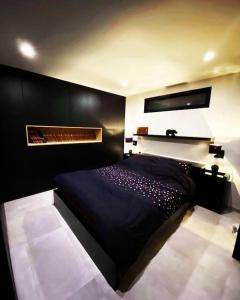 瑟兰Superbe appartement chic et design的一间卧室配有一张黑色的床和一个壁炉