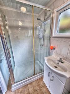 斯旺西Caswell Beach Chalet 70 located in Gower Peninsula的带淋浴和盥洗盆的浴室