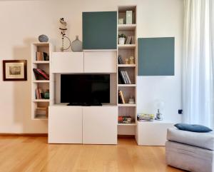 米兰Madeleine apartments - Appartamento di charme的客厅设有带电视的白色娱乐中心