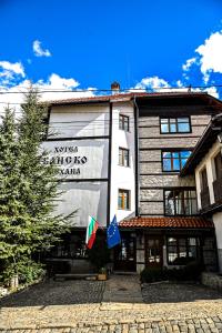 索非亚Family Hotel Bansko Sofia的前面有两面旗帜的建筑