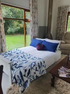 斯托姆勒菲Beautiful garden cottage的一间卧室配有一张带蓝色和白色床单的床和窗户。