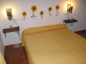 Villarrubia de Santiago卡萨农村拉波萨达德尔弗朗西丝乡村民宿的卧室配有一张带向日葵的床铺,墙上挂有向日葵
