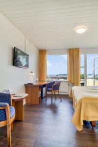 格林哥里皮奈霍斯酒店的酒店客房,配有一张床、一张桌子和椅子