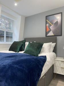 亨廷登Abacus House - TWO Bedroom Apartment的一间卧室配有一张带蓝色床单和枕头的床。