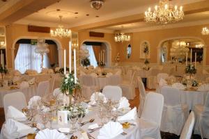 布里德灵顿雷夫尔斯托克酒店的宴会厅配有白色的桌椅和吊灯