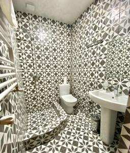 梅斯蒂亚Freeze Inn Mestia的浴室设有黑色和白色的瓷砖墙