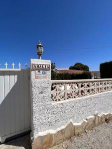 卡尔佩¡Magnifica Villa Amalia!的围栏旁的石柱,上面有标志