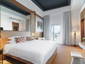 拉纳卡Leonardo Boutique Hotel Larnaca的一间卧室设有一张大床和一个大窗户