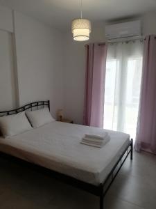 Mesaíon KarlovásionBrand new cozy apartment的一间卧室配有白色床单和粉红色窗帘