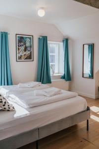 艾勒斯克宾KEFS Guesthouse & Café的一间卧室配有一张带蓝色窗帘的大床