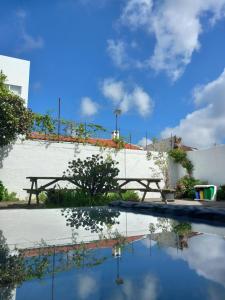 蓬塔德尔加达City's Hostel Ponta Delgada的一座带野餐桌和天空云的游泳池